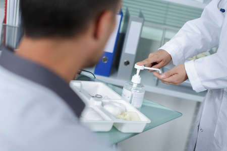 Medical worker dispensing antibacterial gel onto handの写真素材