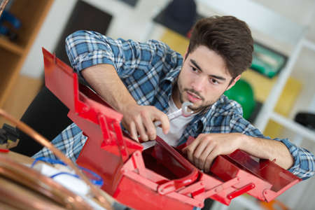 Young man with open toolboxの写真素材