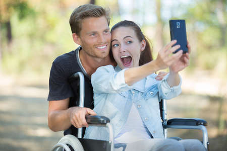 young pretty girl taking a selfie with a manの写真素材