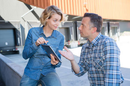 businesspeople having a meeting outdoors with tabletsの写真素材