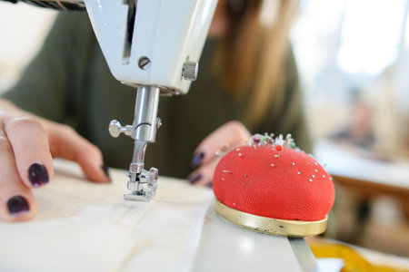 woman sewing on sewing-machine focus on sewing-machine