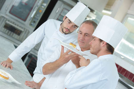 cooking lesson with two apprenticesの写真素材