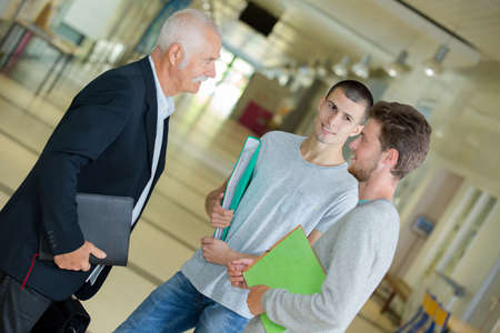group of college students talking to teacher on university hallの写真素材