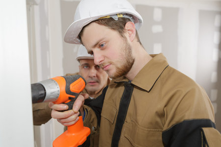 man drilling the wall with drill