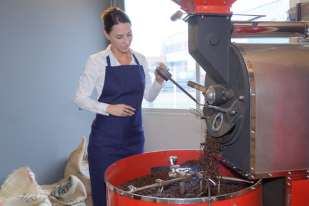 female worker roasting coffee beans at a factoryの写真素材
