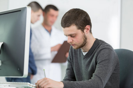 young male student and a computer screen