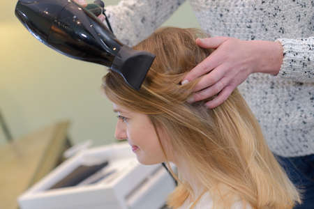hairdresser blow drying hairの写真素材