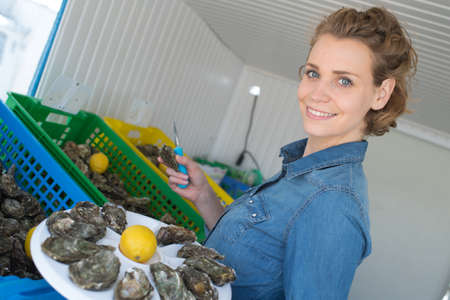 woman with a plate of oysterの写真素材