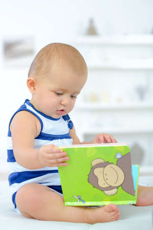 baby curious with a bookの写真素材