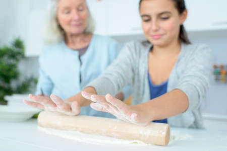 grandmother cooking apple pie with little girlの写真素材