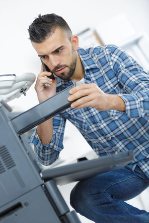 man inspecting the printing machine