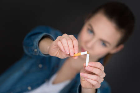 young woman breaking the cigaretteの写真素材