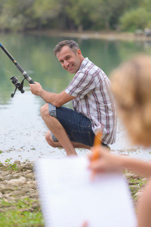 Man fishing, woman drawing