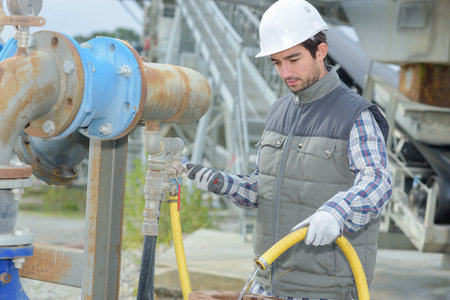 Man holding hose on construction site