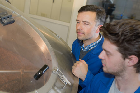 Men looking into vat