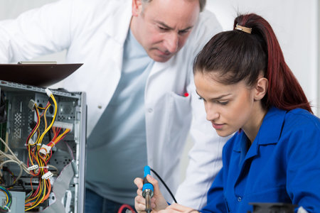 Young worker learning to use soldering iron