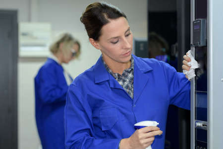 Woman cleaning glass cabinetの写真素材