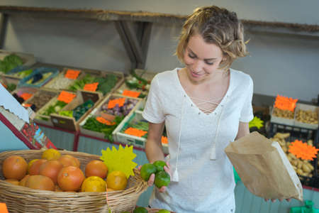 Woman holding peppers and paper bagの写真素材