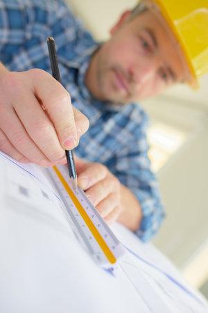 architect rectifying  some plans at a site