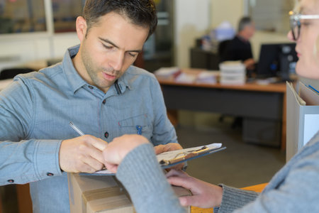 man signing for the delivery of boxes