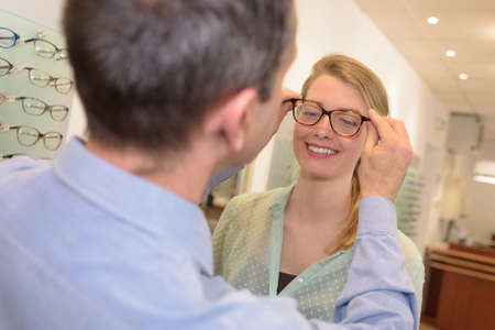 woman choose eye glasses and trying different designsの写真素材