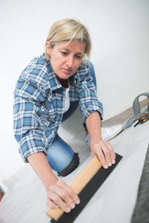 woman fitting a linoleum floorの写真素材
