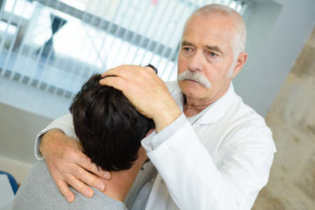 senior doctor doing head manipulation on patientの写真素材