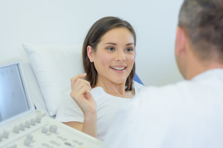 doctor talking to happy pregnant patient