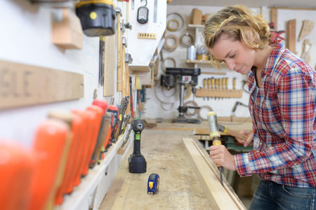 confident female carpenter with a chisel