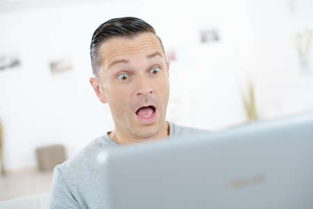 shocked businessman working on computer in his officeの写真素材