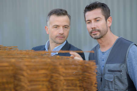 2 construction workers inspecting metal traysの写真素材