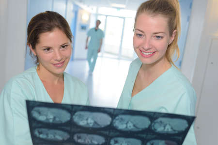 two female doctors checking patients xray in hospitalの写真素材