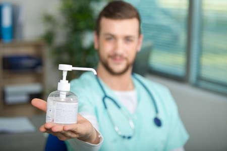 doctor showing a hand gel pump bottleの写真素材