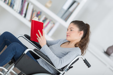 girl in wheelchair with a bookの写真素材