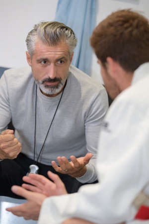 coach talks to young football player before matchの写真素材