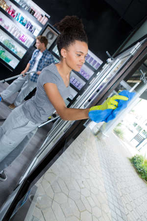 woman cleaning window with special cleanerの写真素材