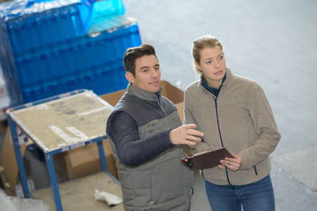 portrait of workers are looking a clipboard in a warehouseの写真素材