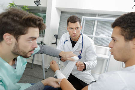 nurse putting bandage around the armの写真素材