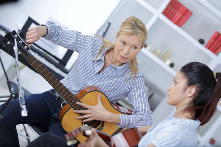 Guitar teacher tuning guitarの写真素材