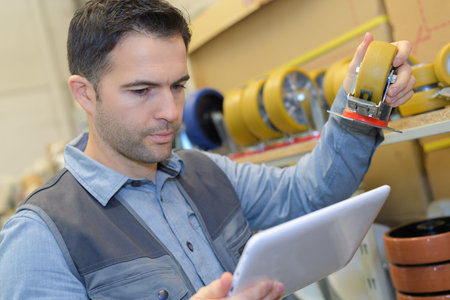 standing worker holding digital tablet in warehouse