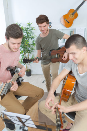 teenagers playing guitar at home
