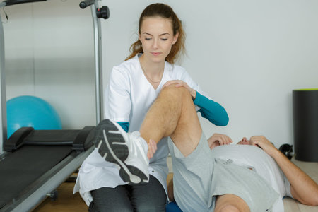 physiotherapist working on the leg of a man