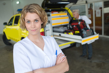 nurse posing next to a medical car