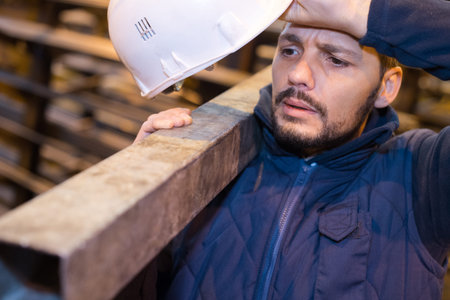 man builder carrying woodの写真素材