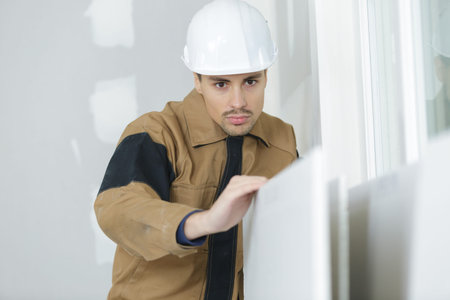 young builder sanding the door before refinishing at home