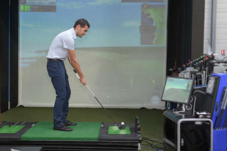 handsome young man playing virtual golfの写真素材