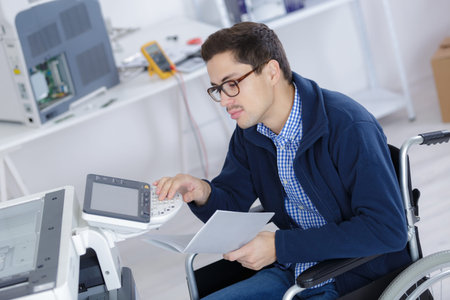 young disabled technician using printer in officeの写真素材