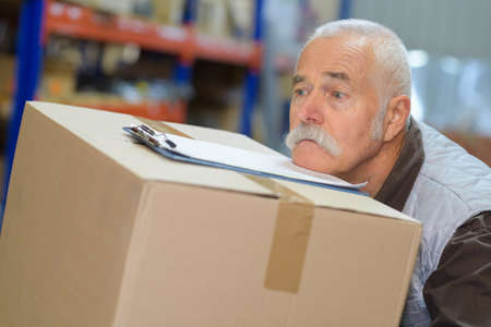 senior man struggling with a delivery boxの写真素材