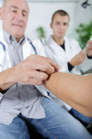 doctor disinfecting the skin before an injectionの写真素材