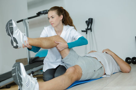 female physio therapist working on male patients legs